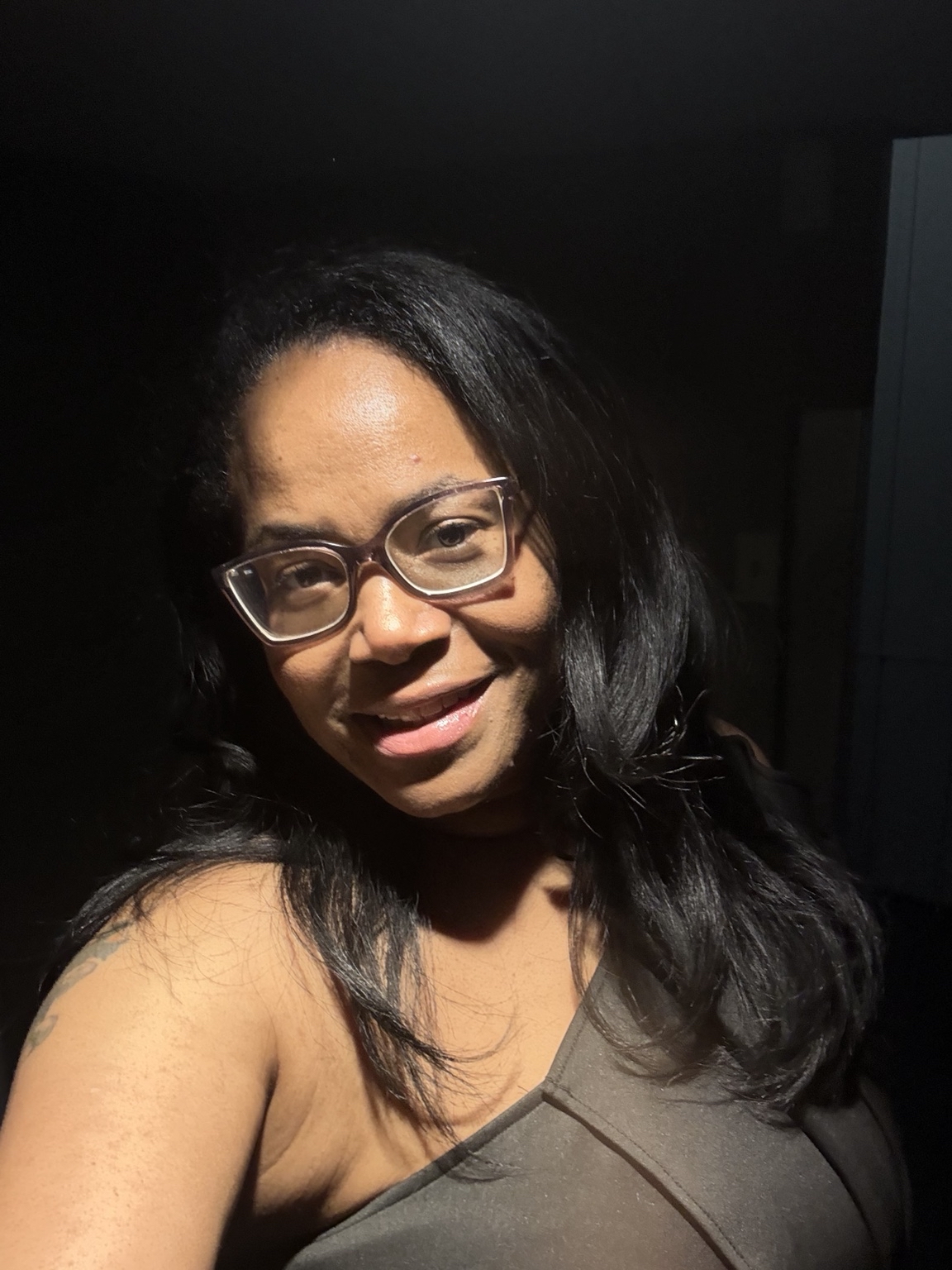 Portrait of Electa smiling in a warm, natural light setting.